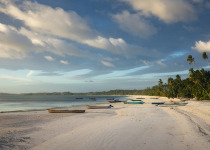 Famous scenic Ngurbloat or Long Beach, tropical coast white sand beach and fishermen's boats in Langgur, Kei islands, Maluku in warm colors of sunset.