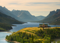 A view of Upper Waterton Lake during the early morning with a landmark Hotel building on a peninsular in the foreground.