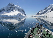 A small cruise ship makes passage through the Lemaire Channel in Antarctica